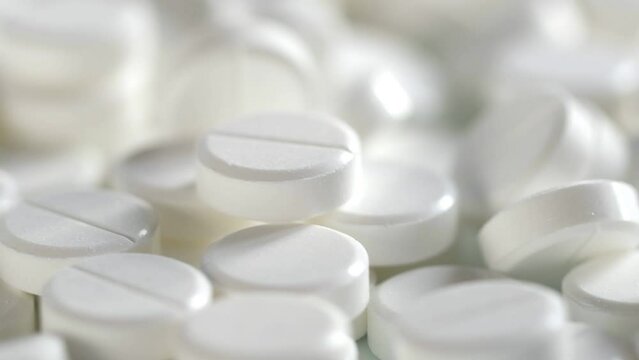 The medicine concept.white medical pills rotating closeup. Pills and drugs. Pharmaceutical Industry.many white round pills. pharmaceutical production. drugs on the production line. moving background