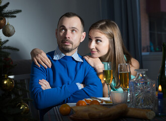 Wife apologizing her offended husband after quarrel on Christmas night