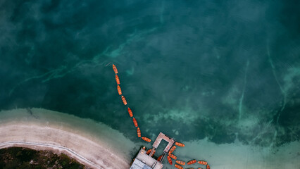 Aerial drone view of wooden boats on water surface with blue sky reflection in lake. Braies Lake, Italy