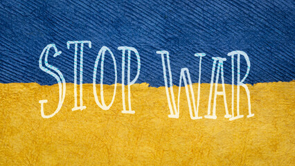 stop war text against paper abstract in colors of Ukrainian national flag - blue and yellow