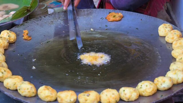 Aloo tikki, aloo ki tikki or aloo tikia is a Indian steet food made of smashed potatoes, delicious and popular vegeterian fast food in India. 4k video of making aloo tikki on kadai, for cooking.