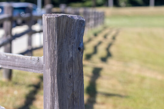 country wooden fence post along green field