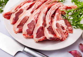 Chops of fresh raw lamb ribs with garlic and greenery. Ingredients for cooking