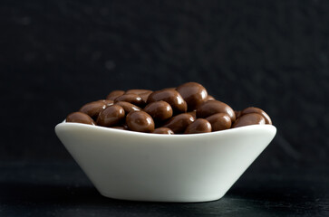 Chocolate Raisins in White Bowl with Dark Background