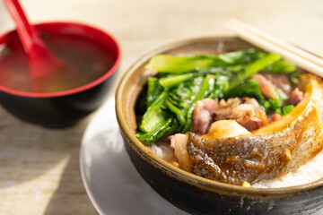 angle view clay pot rice with fish and pickled duck and vegetable