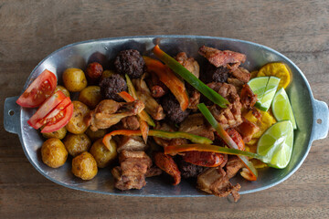 fried or chopped, traditional Colombian food, composed of fried meatballs, chicken, creole potato, pork rinds, banana, lemon and tomato