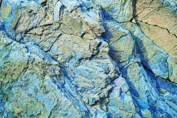 Abstract blue yellow brown background. Colorful rock texture. Cracked layered mountain surface....