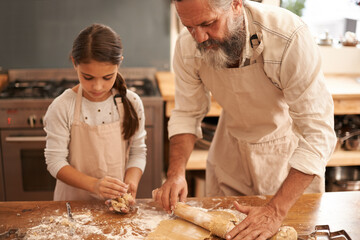 Theyre serious about baking. Shot of a girl and her grandfather baking together in the kitchen.