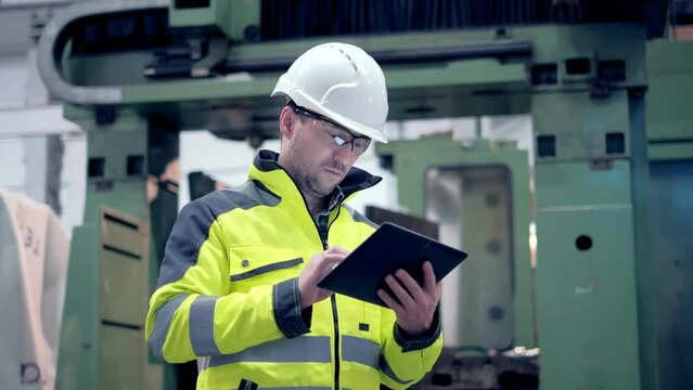 Engineer Is Using Tablet Pc In Factory. Slow-Motion.