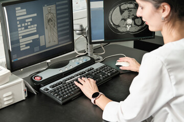 middle east woman doctor looking at monitor with computer tomography image. female young radiologist examining ct test results.