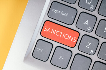 Close-up of the red button with the text of the sanction on the conceptual keyboard.