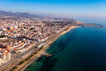Aerial view of coastal town of Premia de Mar on Catalan coast of turquoise Mediterranean Sea with marina on warm winter day, Maresme, Spain
