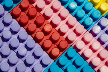 children's play background: the plane of plastic multi-colored bricks, blur, selective focus