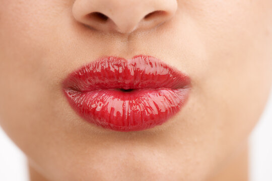 A glossy red pout. Cropped closeup shot of a young woman pouting.
