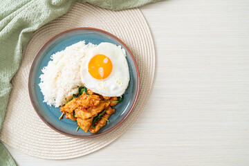stir-fried fried fish with basil and fried egg topped on rice