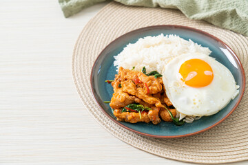 stir-fried fried fish with basil and fried egg topped on rice