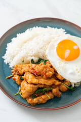 stir-fried fried fish with basil and fried egg topped on rice