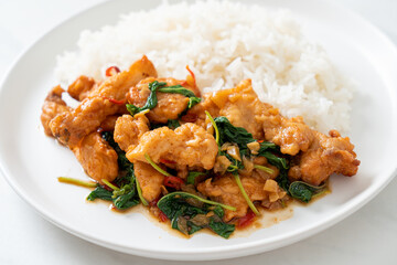 stir-fried fried fish with basil and chili in thai style topped on rice