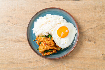 stir-fried fried fish with basil and fried egg topped on rice