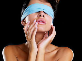 Discover your beauty. A head and shoulders shot of a beautiful model wearing a blue blindfold and...