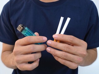 Young man holding a cigarette and matches in his hand.