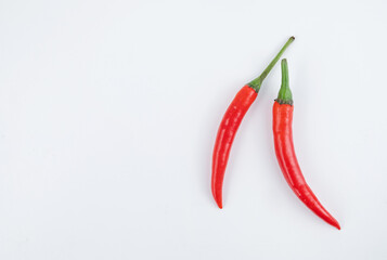 Two red hot chili peppers on a white background close-up. Gop view and copy space