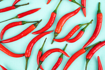 A pattern of red hot chili peppers on a blue background close-up. Top view