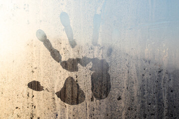 Handprints on the cold glass of the window.