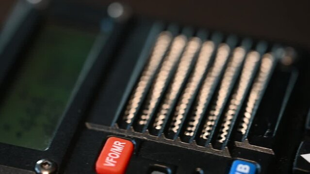 fast slide from bottom to top of a modern handheld HAM radio that lights up when a signal comes in