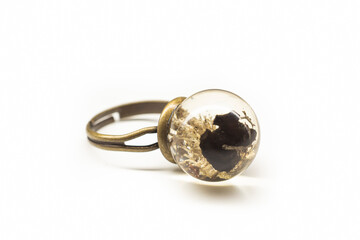 Bronze ring with moss and lava rock. Transparent epoxy resin jewelry with organic geologic formations. Selective focus on the details, object isolated on white background.