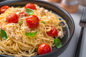 Pasta with feta, cherry tomatoes, herbs and basil close-up.