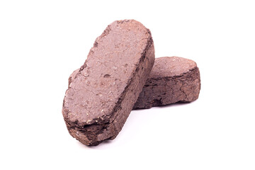 white background. the briquette is dark in color. an alternative type of fuel for heating. close-up.