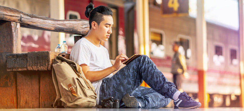 young hipster man relax using digital tablet online planning tourist travel holiday city street , journey backpack adventure outdoor by train.
