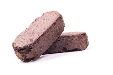 white background. the briquette is dark in color. an alternative type of fuel for heating. close-up.