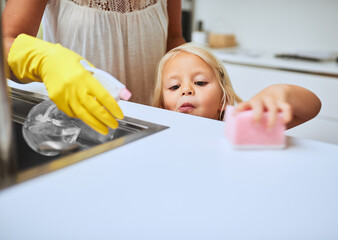 Keeping their home clean and shining. Shot of a mother and her little daughter cleaning a kitchen...
