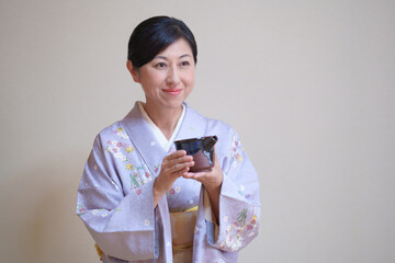着物姿でお酒を勧める日本人女性　お酒の片口を持つ中年女性