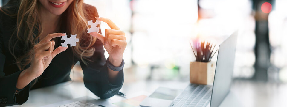 Businesswoman hand connecting jigsaw puzzle with sunlight effect, Business solutions, success and strategy concept, banner background.
