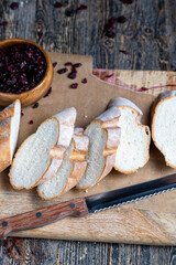 cranberry and sliced soft fresh baguette on a cutting board and table