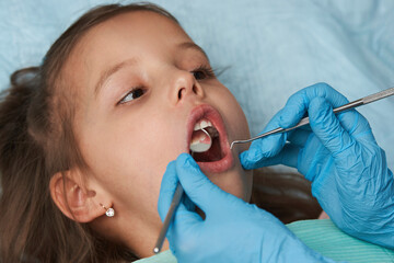 Little girl with open mouth sitting in the dentist's chair