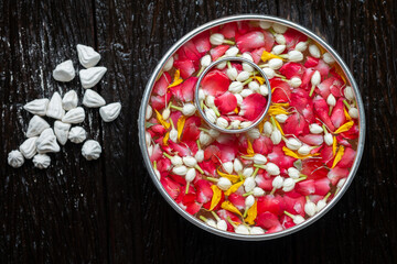 Roses, jasmine and marigolds In a large silver bowl on a wooden floor , Songkran Festival or Thai New Year