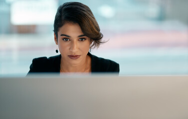 Dont tell anyone your plans, show them your results. Cropped shot of an attractive young businesswoman sitting alone and working on her computer in the office.