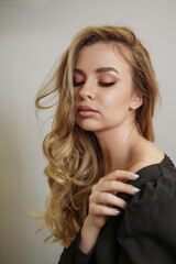 Beautiful young blonde woman face closeup portrait in studio on a light background