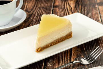 Delicious lemon cheesecake served with coffee on wooden table