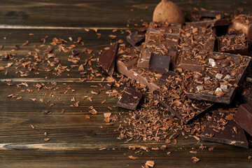Grated chocolate and pieces of tasty chocolate on table