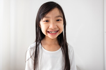 Asian girl wearing removable braces is smiling in a good mood. - obrazy, fototapety, plakaty