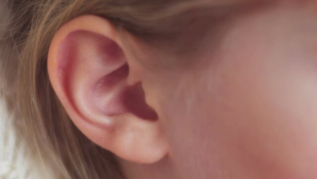 Close-up of a child's ear. Moves the ear