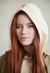 Vertical close-up portrait shot of attractive young Caucasian woman with red hair and gray eyes...