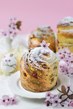 Baking craffin on a white table against a backdrop of cherry blossoms. Side view. Vertical orientation