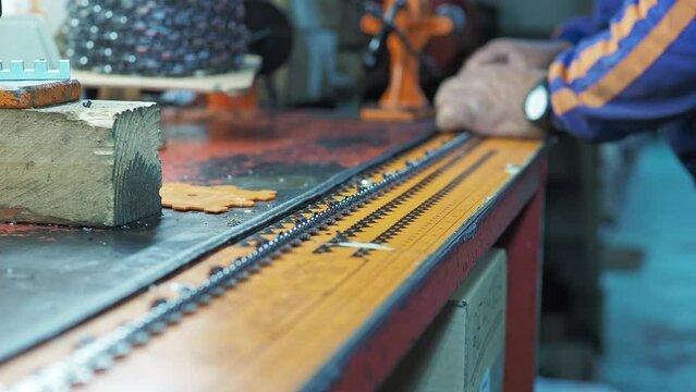 Man measures chain saw to cut to the size required by the customer. Selective focus shot