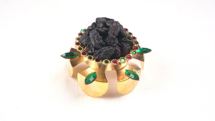 black raisins in a bowl on a wooden table. black raisins in a spoon